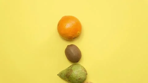 Eat fruit text written with fresh fruit on a yellow background. Stop motion Stock Footage 130242568