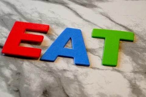 EAT letters on marble background Photos