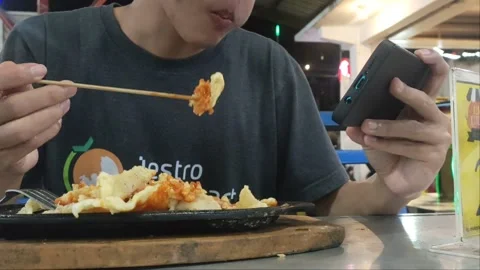 Eat while playing mobile 動画素材 223362314