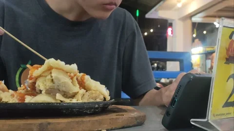 Eat while playing mobile 動画素材 223362328