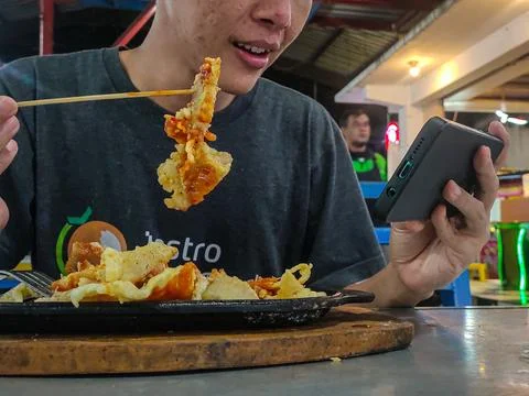 Eat while playing mobile 写真素材