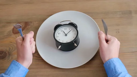 The eater knocks on the table with a fork and knife demanding a serving Stock Footage 128254173