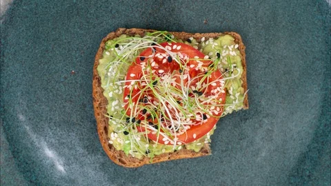 Eating avocado toast bite by bite looped stop motion. Stock Footage 128923292