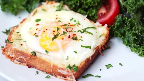 Eating baked egg and cheese toast with salad on a white plate Stock Footage 134936732