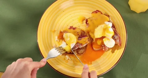 Eating Benedict eggs on a plate. Colored background. Smooth camera movement. Stock Footage 242411321