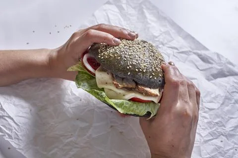 Eating black burger Stock Photos