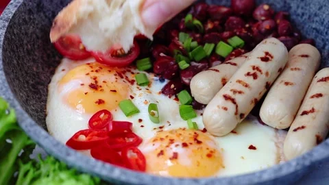 Eating with bread fried eggs, sausages and beans - breakfast in pan. Homemade Stock Footage 130618562