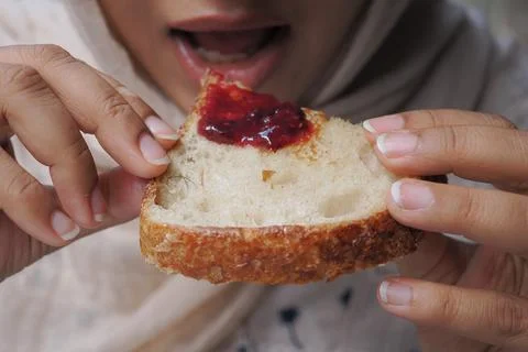 Eating bread with jam in a casual setting Stock Photos