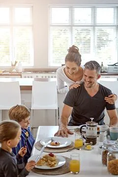 Eating breakfast helps them to develop healthy eating habits. a family having Stock Photos
