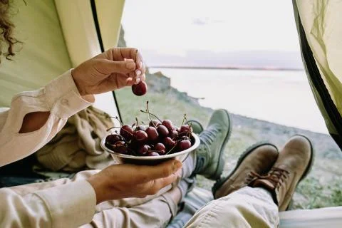 Eating cherries in camping tent Stock Photos