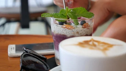 Eating Chia Pudding and Drinking Coffee in Cafe. Superfoods Concept Stockbeeldmateriaal 75045133