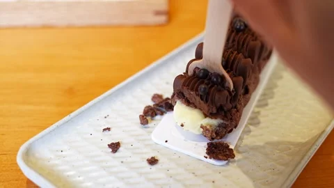 Eating  chocolate eclair puff with whipped cream in a white plate Stock Footage 282067621