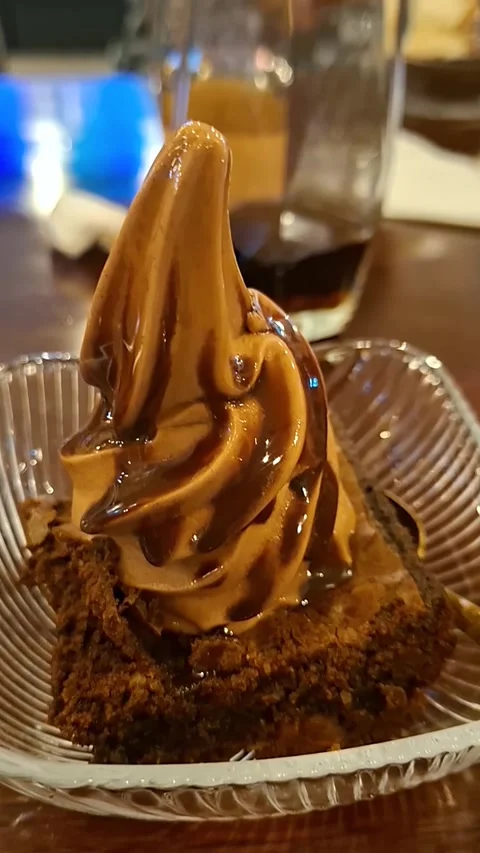 Eating Chocolate Soft-Serve Ice Cream Atop a Warm Brownie Video stock 336589127