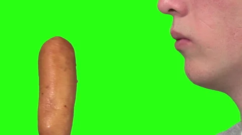 Eating a corndog, green background Stock Footage