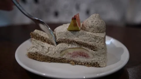 Eating fig cake on wooden table with a silver spoon. 스톡 동영상 344514517