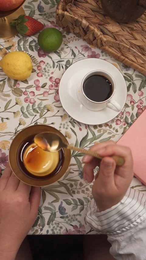 Eating flan pudding beside black coffee and notebook top view Stock Footage 335422390
