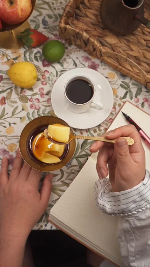 Eating flan pudding beside black coffee and notebook top view Stock Footage 335422401
