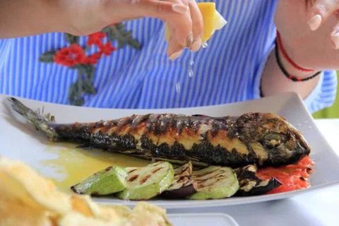 Eating grilled fish Stock Photos