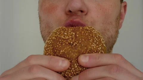 Eating a hamburger close-up. A man eats a bun. Bite the delicious bread Stock Footage 279854588