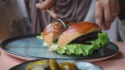Eating a hamburger in a restaurant with sides on the table Stock Footage 346515584
