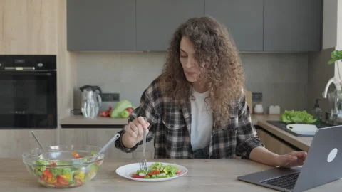 Eating Healthy Salad While Working Remotely At Kitchen Counter With Laptop Stock Footage 311271529