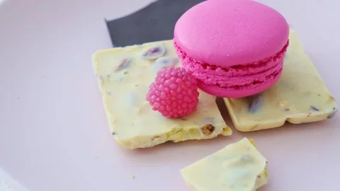 Eating macarons of different colors on a pink plate Stock Footage 255639811