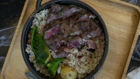 Eating medium rare wagyu beef steak over rice fusion Asian twist food Stock Footage 115789741