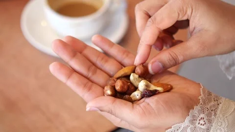 Eating mixed nuts with a cup of coffee in a cafe Stock Footage 339317072