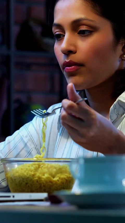 Eating noodles while working, Indian businesswoman joins video call at office Stock Footage 342572835