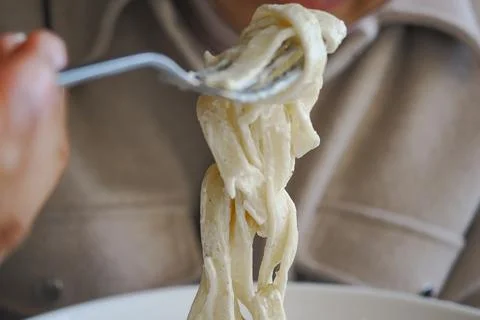 Eating pasta with a fork in a restaurant Stock Photos