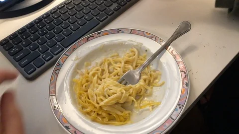 Eating pasta working computer Stock Footage 122102701