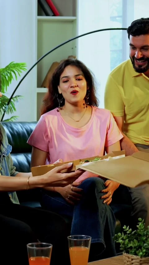 Eating pizza and showing to camera, happy Indian friends relax at home Stockbeeldmateriaal 342385148