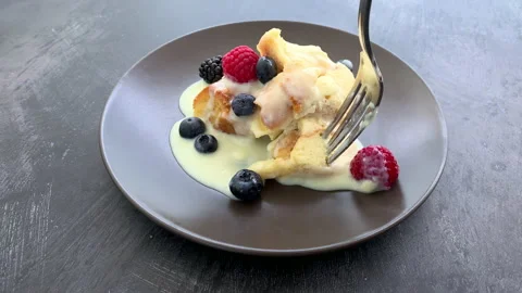 Eating a Plate of Bread Pudding with Custard and Berries Video stock 218312635