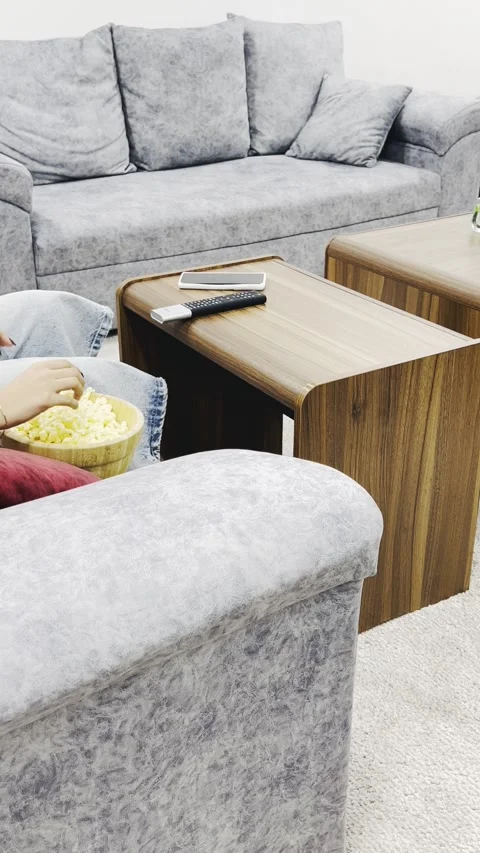 Eating popcorn on a sofa with remote control on table, vertical view Stock Footage 345152565