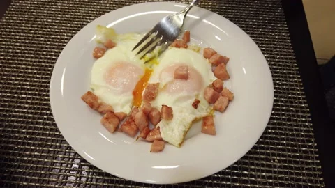 The eating process. The person is having breakfast, the man is eating fried e Stock Footage 154754817