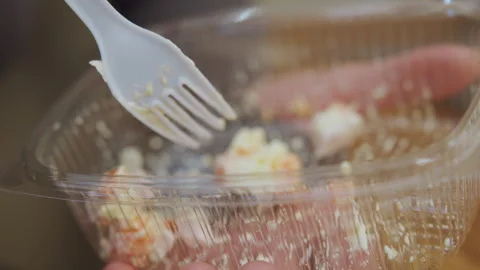 Eating salad quickly. Closeup of someone eating salad from container. Individual Stock Footage 335958693