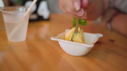 Eating a scoop of mango ice cream Stock Footage 89245789