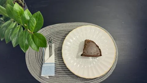 Eating slice of chocolate cake with fork from white plate, top view flat lay Stock Photos