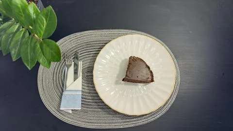 Eating slice of chocolate cake with fork from white plate, top view flat lay Stock-Fotos