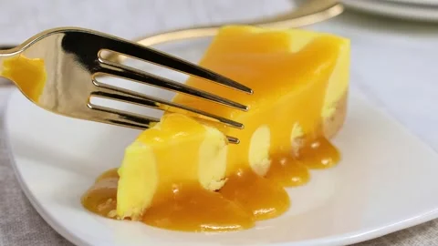 Eating slice of lemon cheesecake on plate with a fork close up Stock Footage 283089948