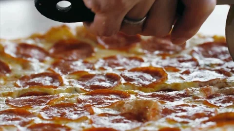 Eating Slice of pizza freshly cooked pizza from oven and places on pizza paddle Video stock 336586763