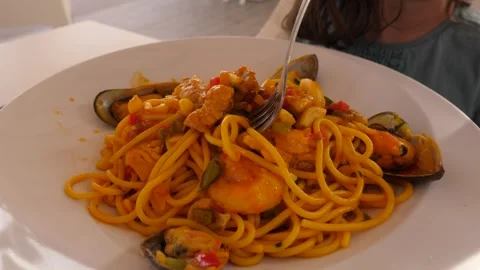 Eating spaghetti with seafood while relaxing at the resort in a restaurant Stock Footage 294322585