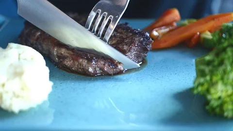 Eating stake from plate with fork and knife Stock Footage 73241530