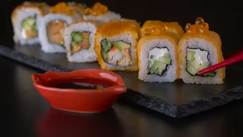 Eating sushi roll set using red chopsticks Stock Footage 69750140