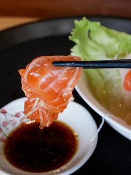Eating sushi with shoyu using bamboo chopsticks Stock Photos