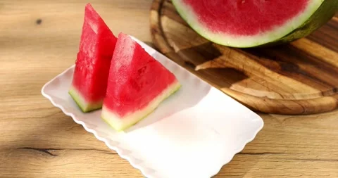 Eating watermelon. Hands take Slices of watermelon from a plate. Stock Footage 249084560
