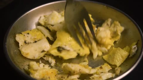 Eating what is left of two whole eggs, freshly cooked early in the morning. Video stock 339100980