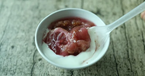 Eating yogurt with fig compote into ceramic bowl Stock Footage 114647294
