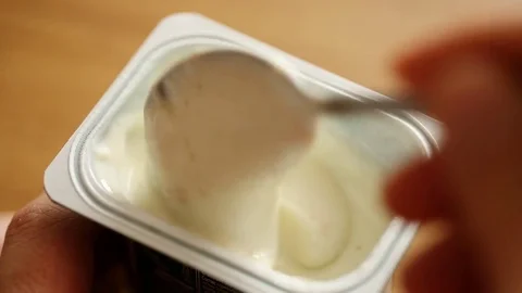Eating yogurt from a plastic cup Video stock 81248934