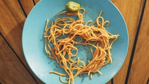 Eats spaghetti from a turquoise plate (top motion) Stock Footage 100901480